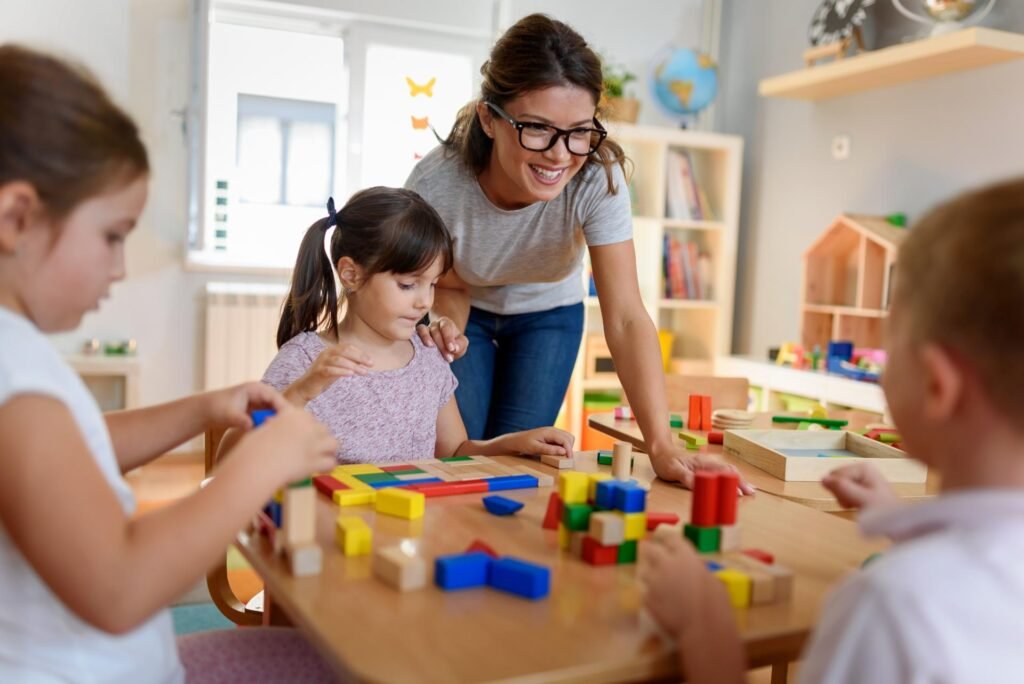 Early childhood educator with children playing with wooden blocks